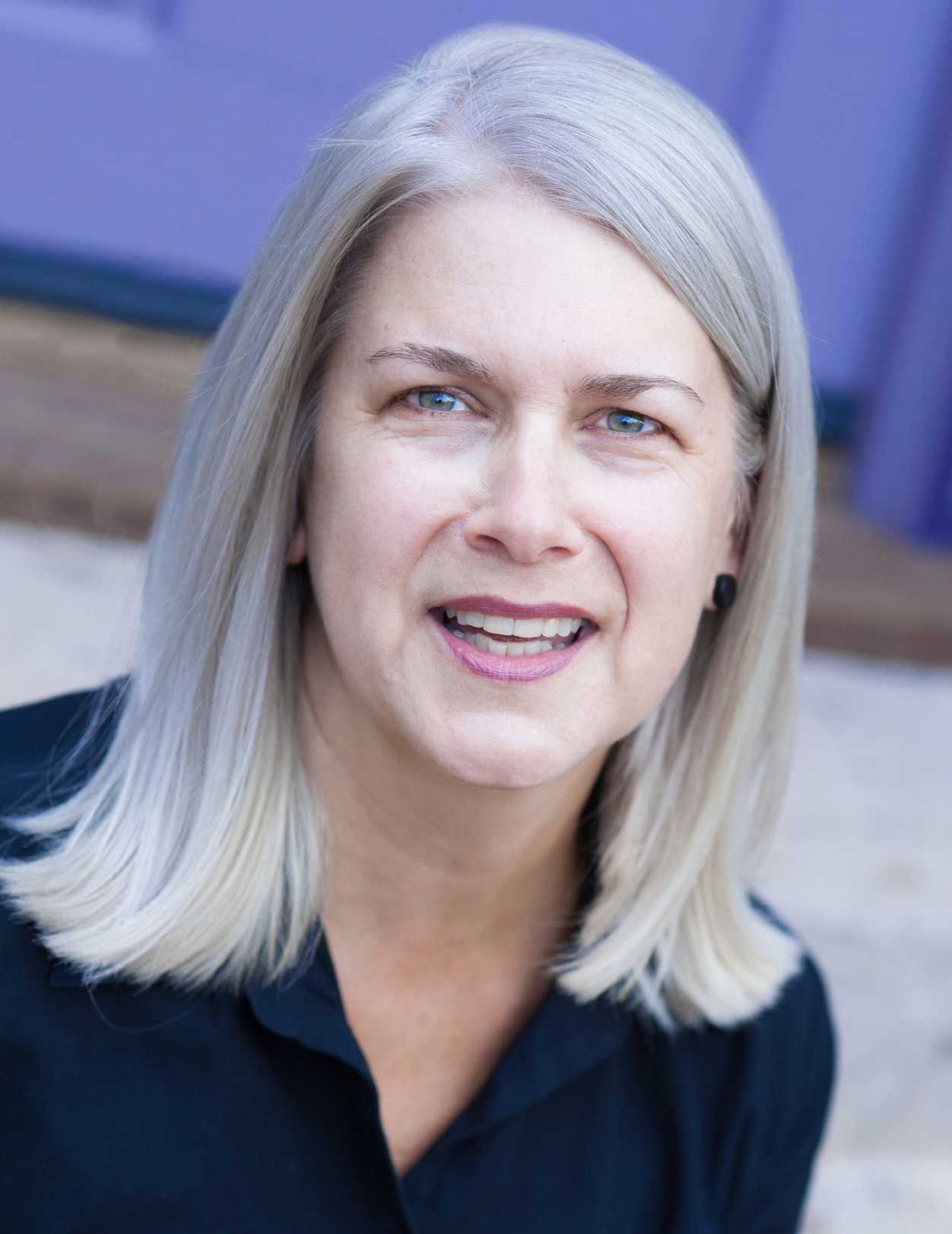 A photo of Lydia Millet, a person with long blond hair and a blue shirt.