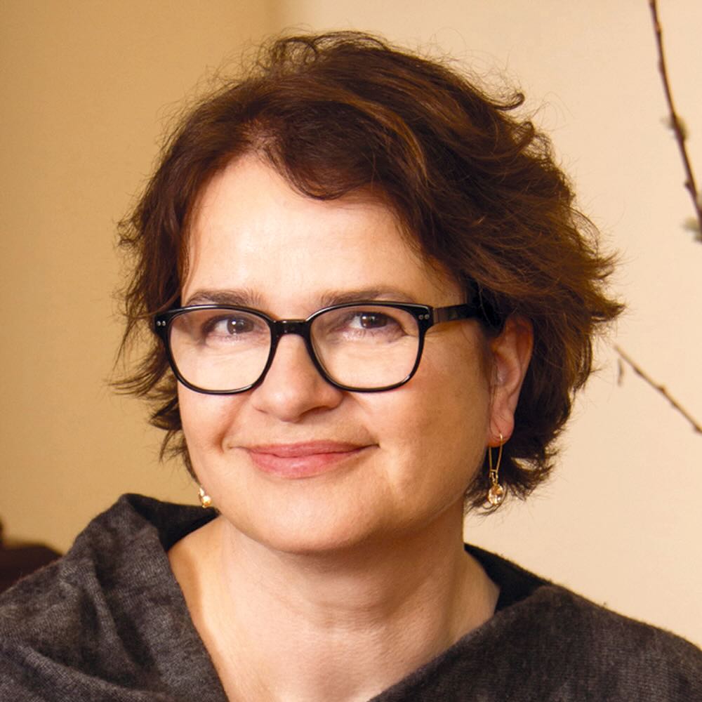 Photo portrait of a person standing in front of a yellow wall.