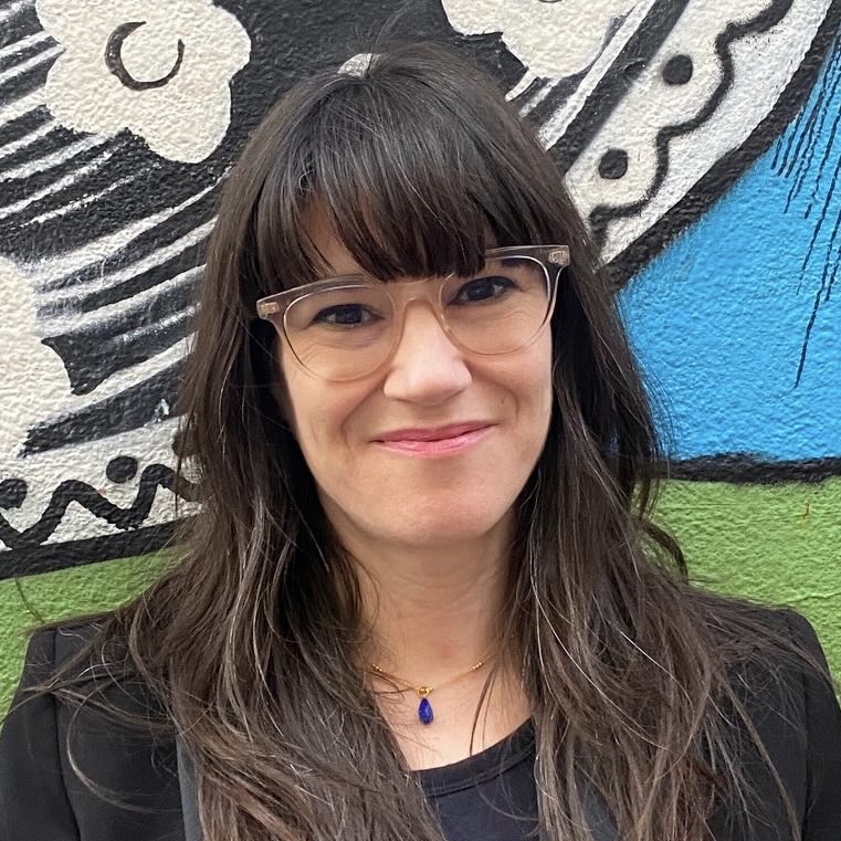 Photo portrait of a person standing in front of a wall mural.