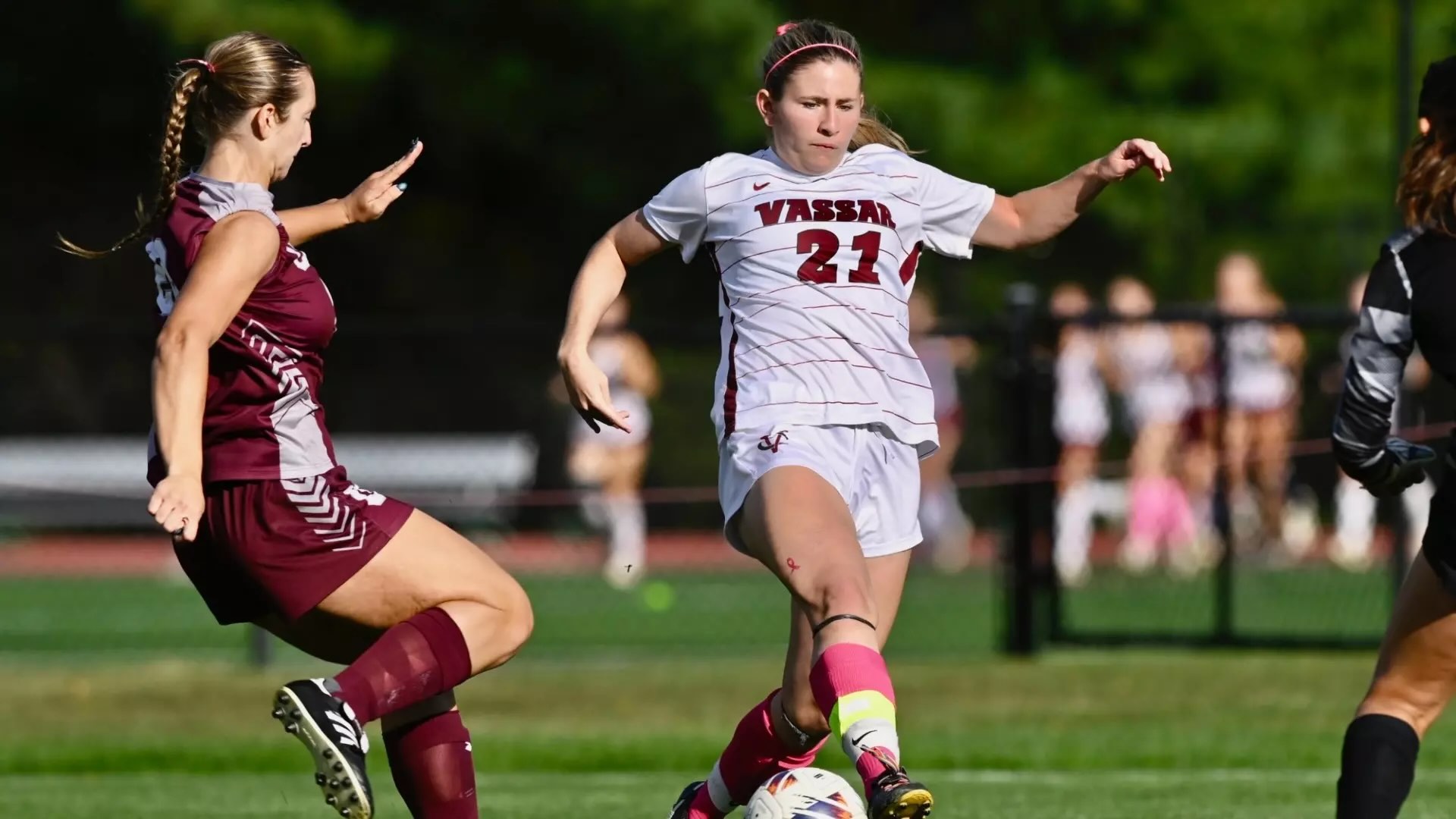 Two soccer players competing on a field.