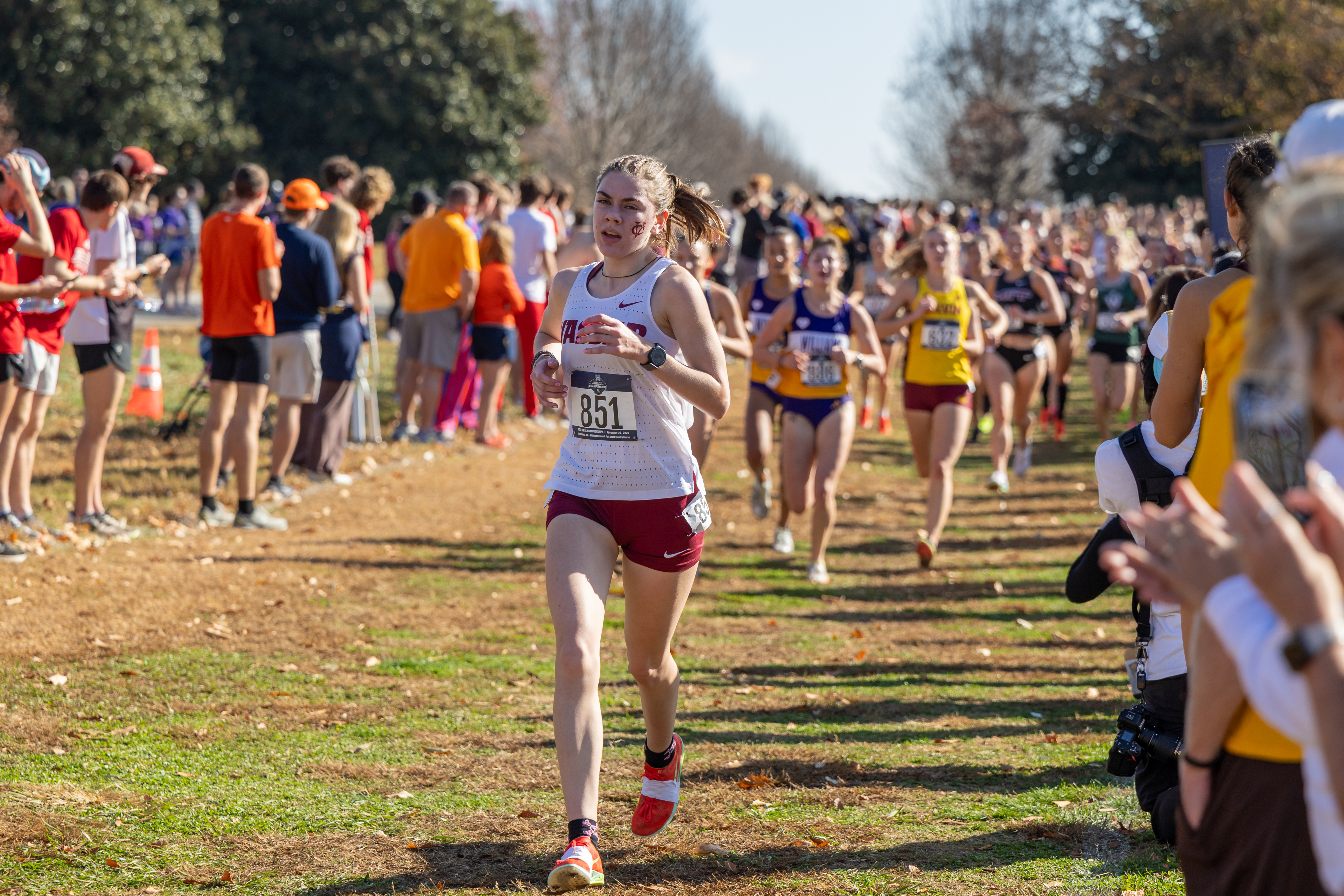 A runner races ahead of the pack on an outdoor course.