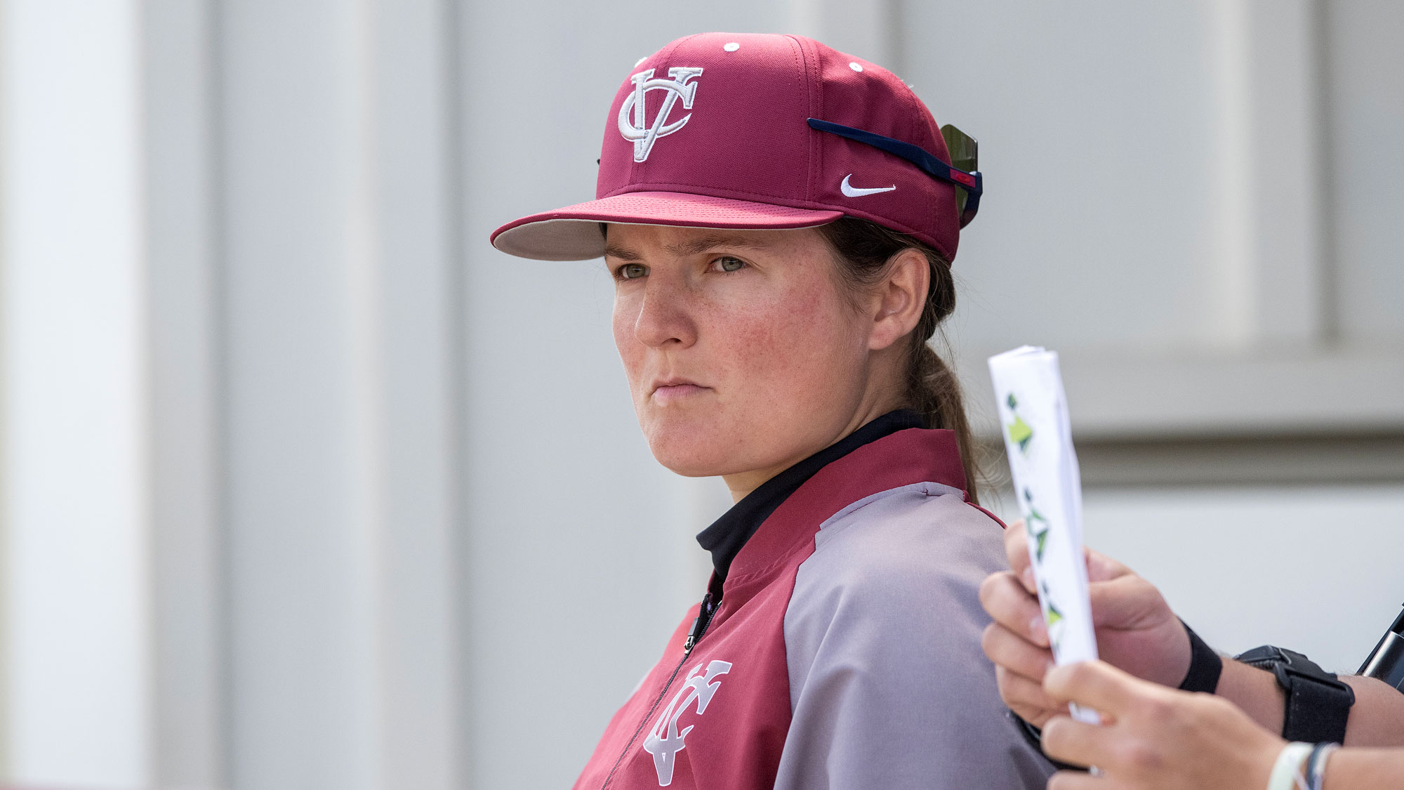 Person wearing a baseball cap staring off screen intensely.