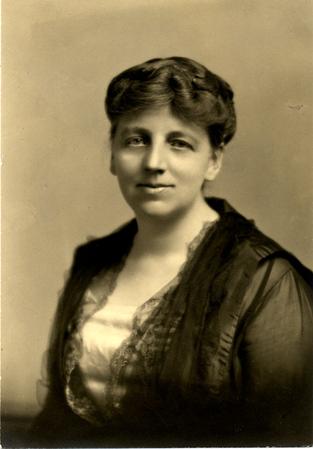 A black-and-white studio portrait of an individual in early 20th-century professional attire.