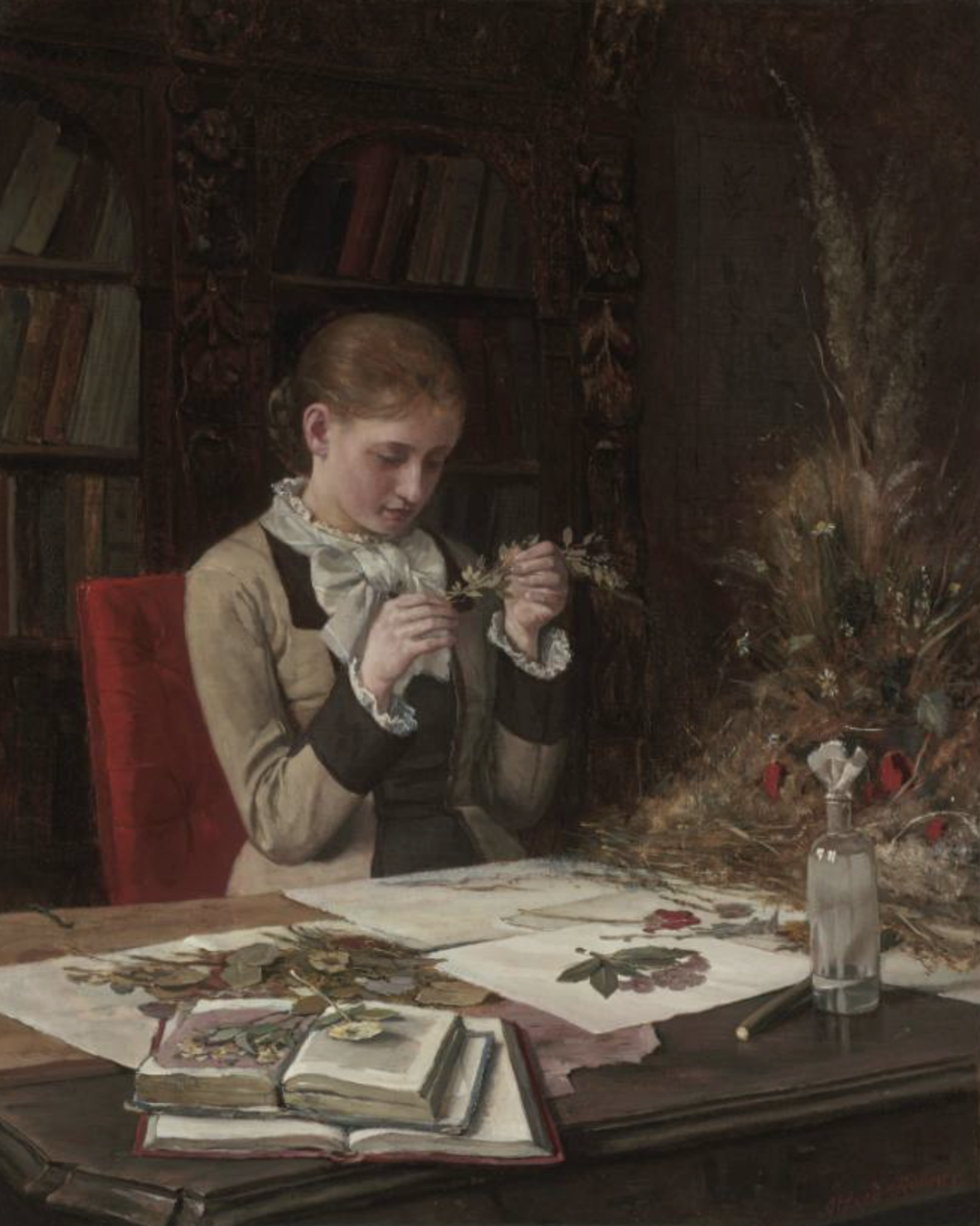 A figure is seated at a wooden table, engaged in arranging pressed flowers. The individual holds a small branch while surrounded by scattered botanical specimens and open books featuring illustrations. Behind, a richly adorned bookshelf is filled with books, its texture contrasting with the smoothness of the table's surface. Warm lighting casts a soft glow over the scene, enhancing the earthy tones of the flowers and the reds of the chair.