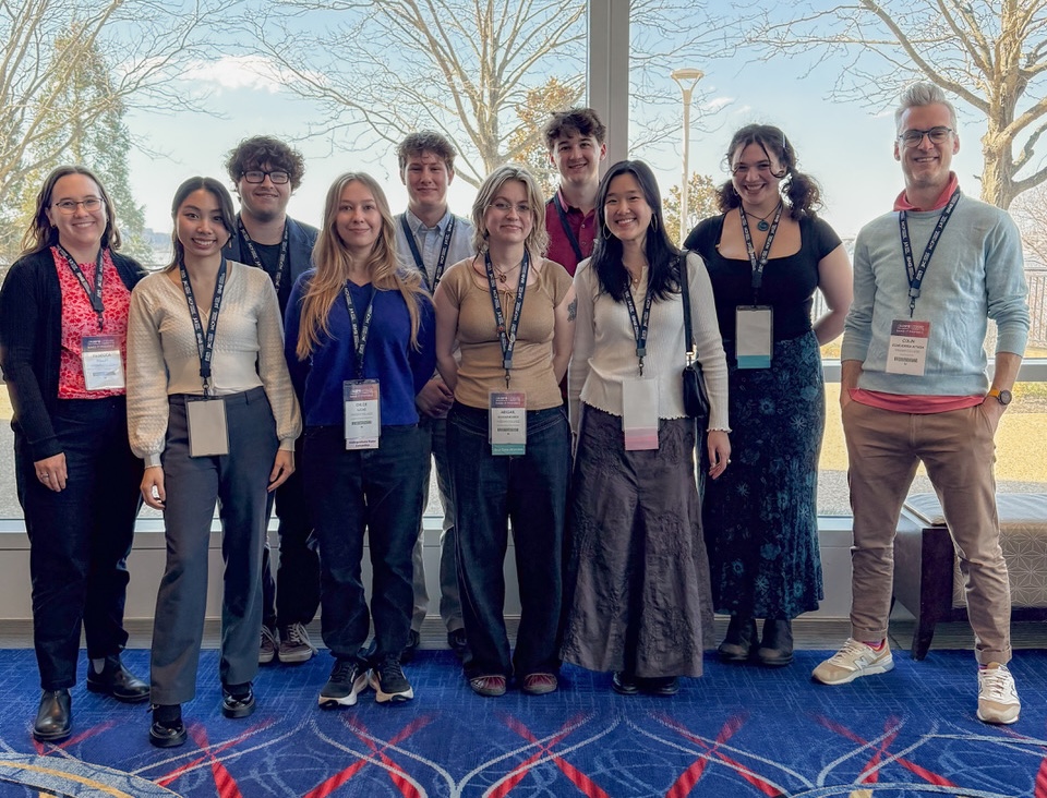 Group photo of 9 students with Prof. Aitken.