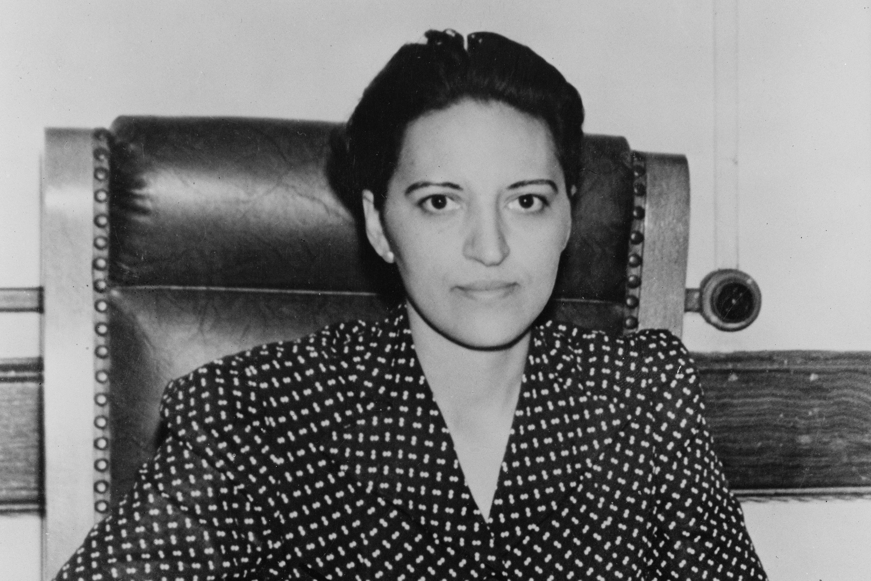 1940s image of a woman sitting at executive desk.