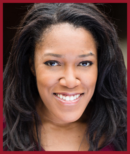 Portrait headshot of a smiling person against a dark background.