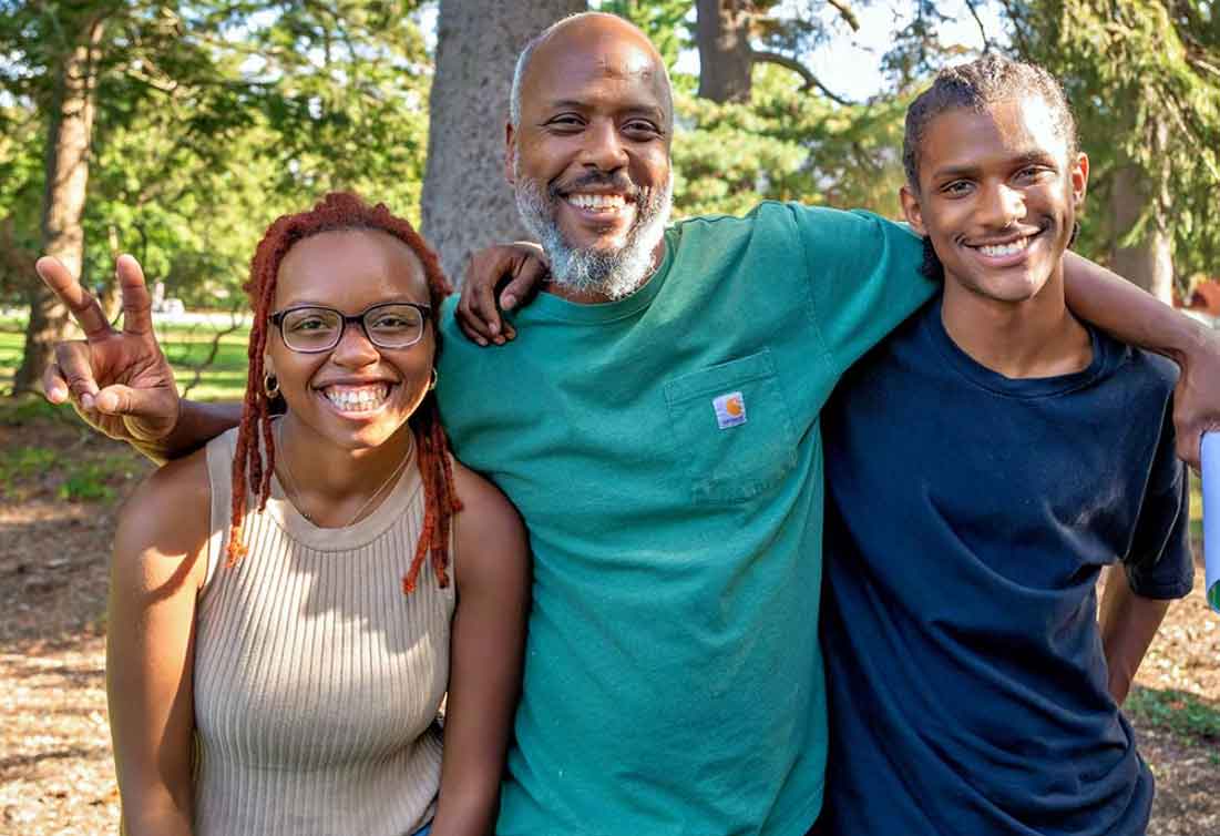 Graphic with a photo of three smiling people arm in arm.