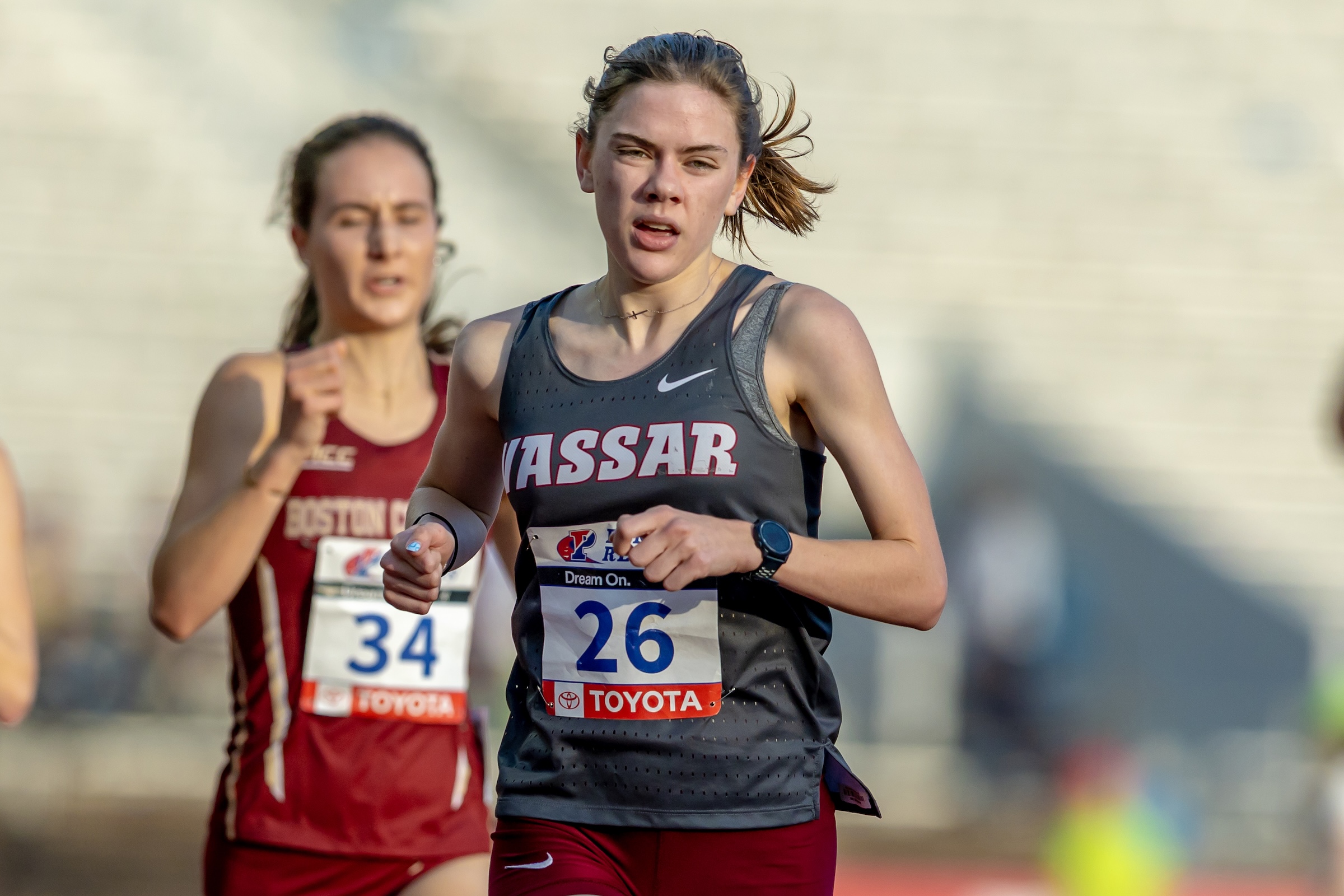 A member of the women's track team runs ahead of the pack.