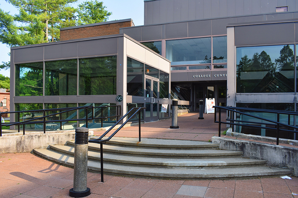 Exterior view of an entrance with stairs in the center and ramps on either side.