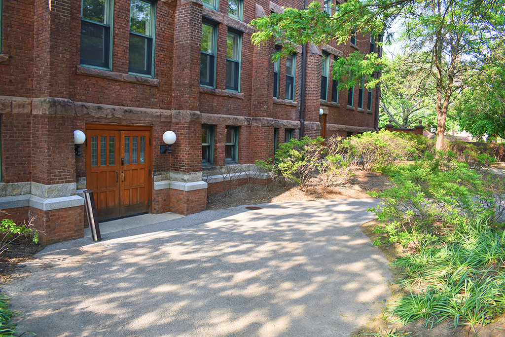 Detail of the exterior of the south side of the building as viewed facing east (from the parking spaces), featuring a set of wide double doors with pull handles.
