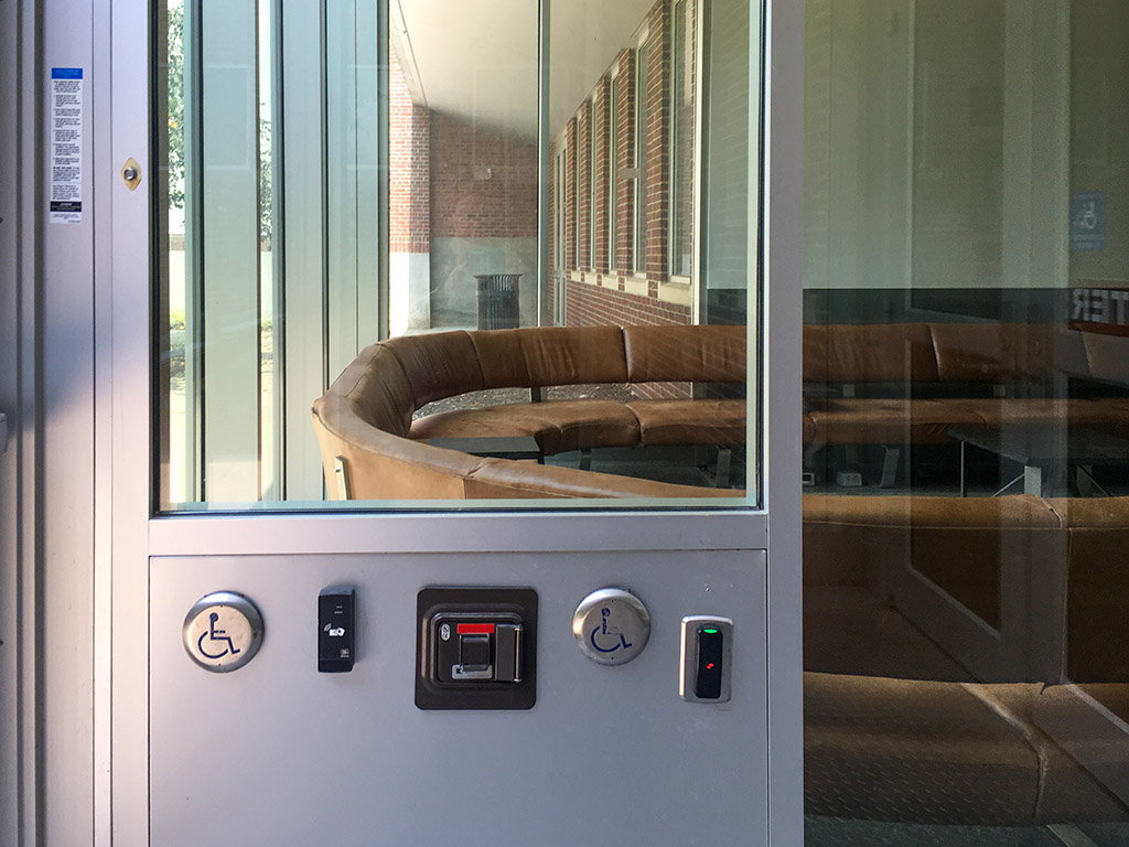 A glass door with a circular table and buttons.