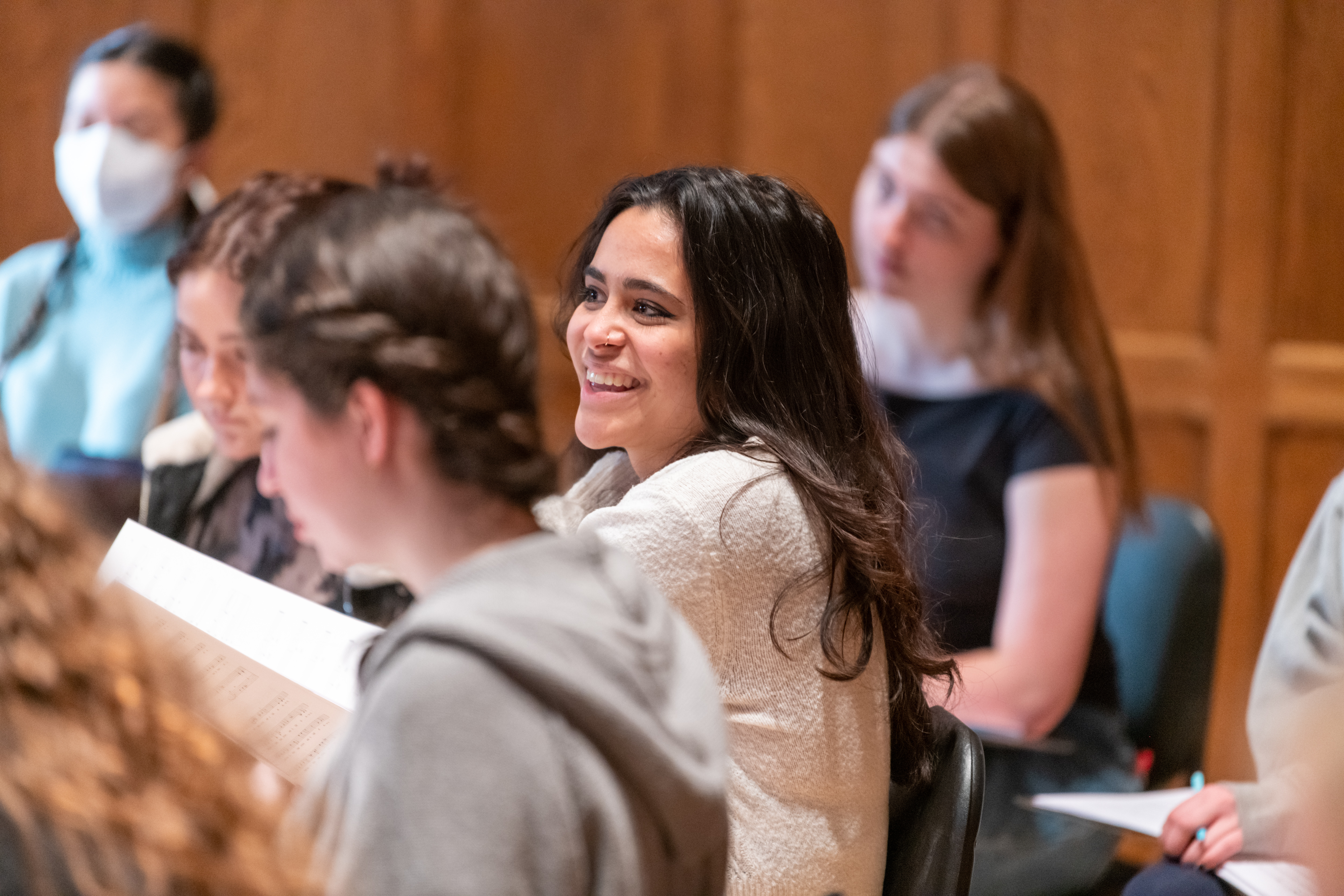 A smiling student rehearses with the Vassar College Chamber Singers.