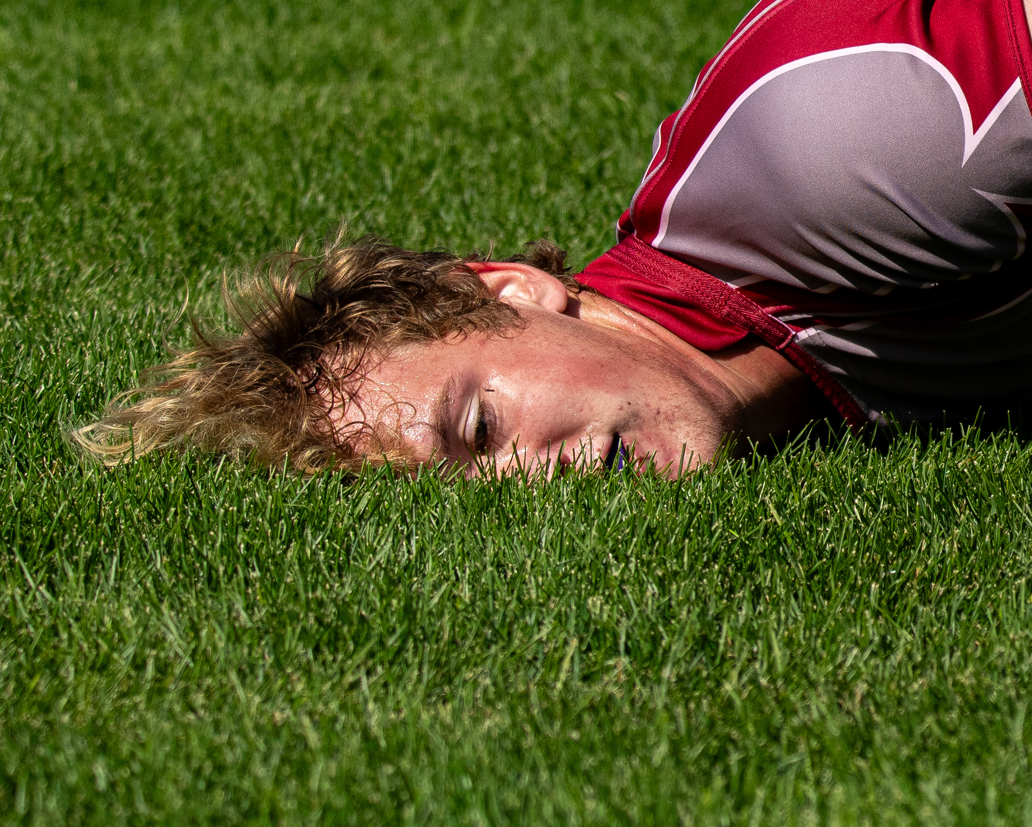 A rugby player lying face first in the grass