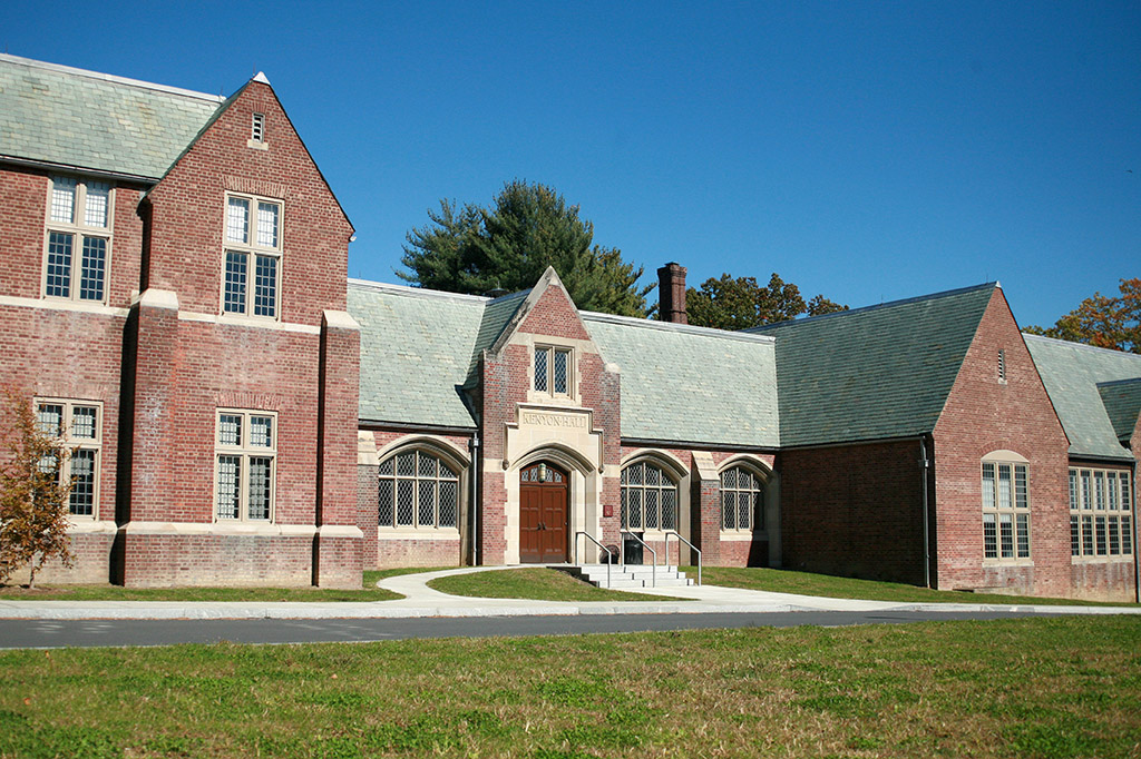 A brick building with a green lawn and a blue sky.
