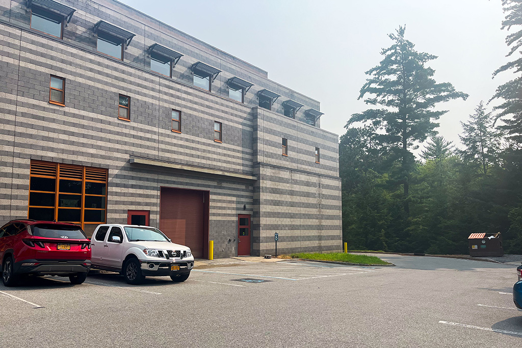 Exterior of the building featuring striped stonework; focused on a loading door with two single doors on either side.
