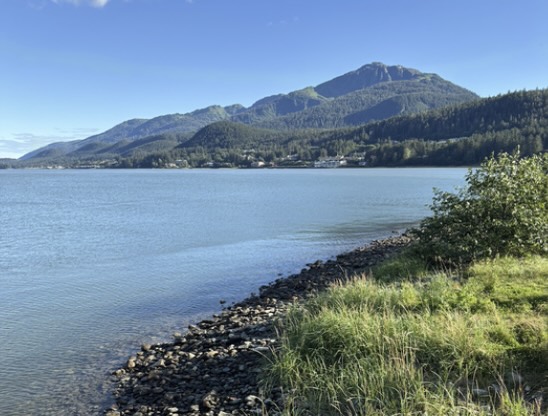 Photo of the ocean and mountains in the background.