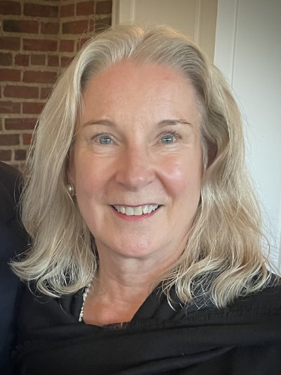 A photo of Kathy Putnam ’75, a person with long blond hair and a dark shirt.