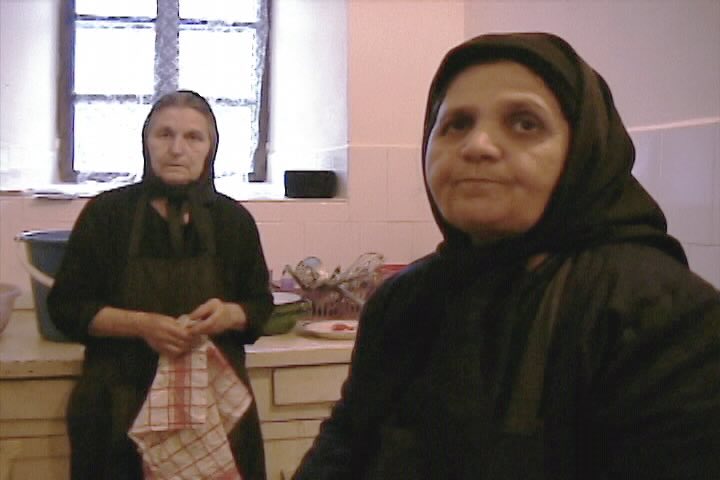 Two people in a kitchen, one holding a towel.