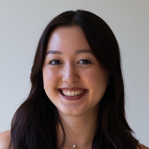 A portrait of Jasmine Haynes, a person with dark brown hair, wearing a black polka-dot camisole and a small pendant necklace.