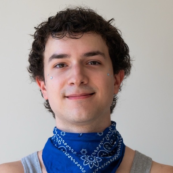 A portrait of Javier Wilson, a person with dark brown curly hair, wearing a gray tank top and a blue bandana.
