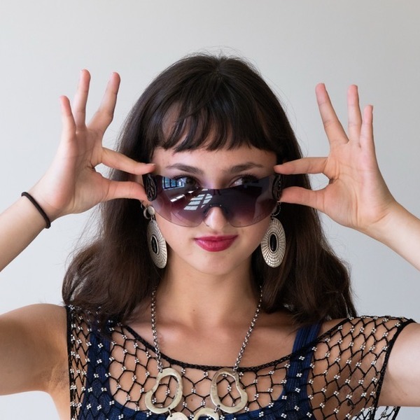 A portrait of Madeline Hsiao, a person with dark brown hair and bangs, wearing tinted sunglasses, a navy top, and a netted overlay.