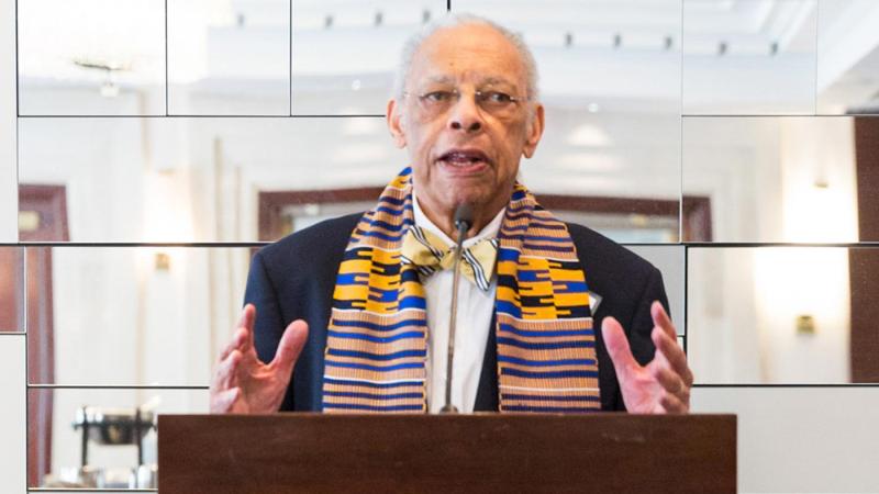 Vassar architecture professor Jeh Vincent Johnson standing at a podium 