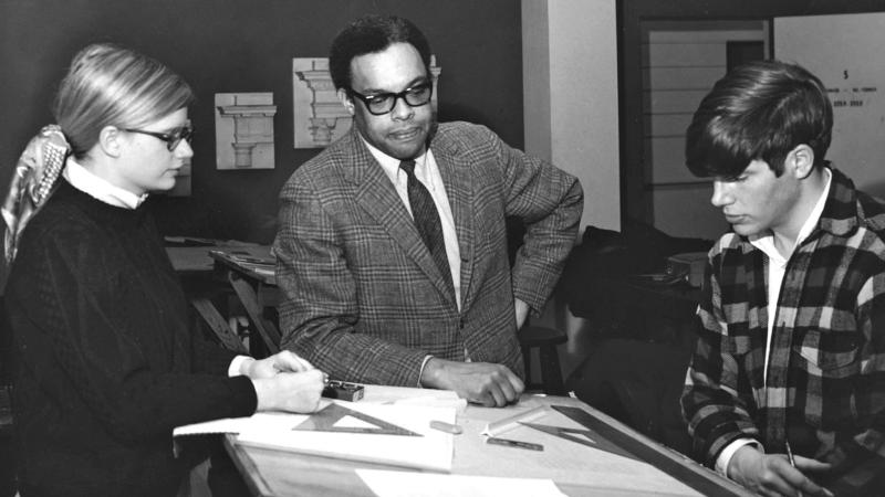 People standing around looking a some blueprints