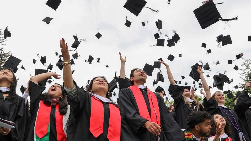 Jubilant graduates throw their mortar boards in the air.