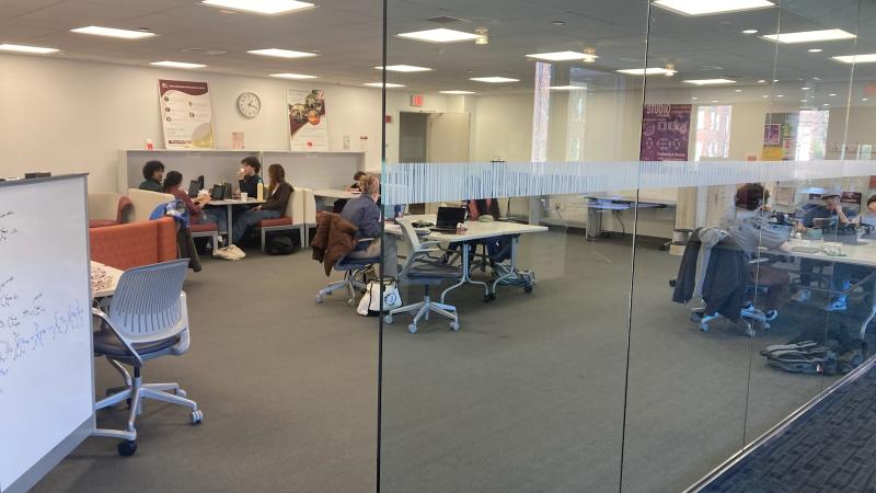 A large open room with desks with privacy dividers.