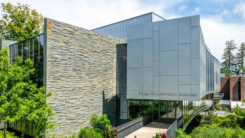 Bridge for Laboratory Sciences at Vassar College, a large glass and brick classroom building surrounded by trees and flowers..