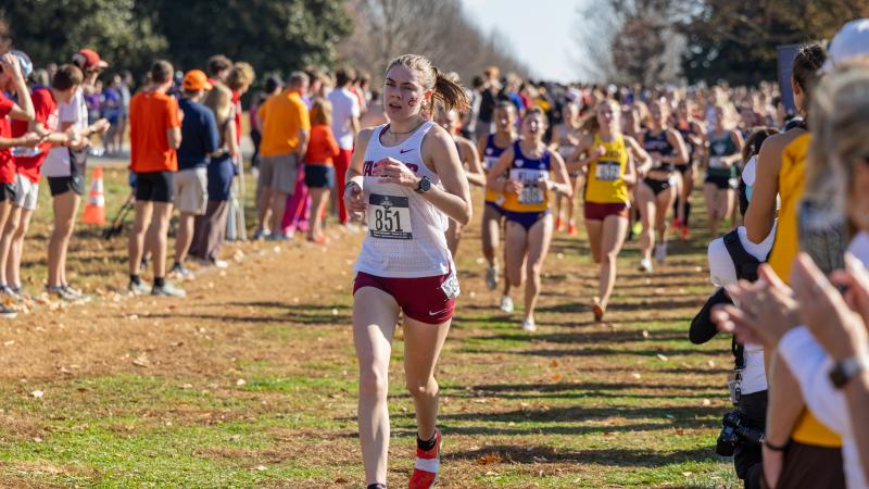 A runner races ahead of the pack on an outdoor course.