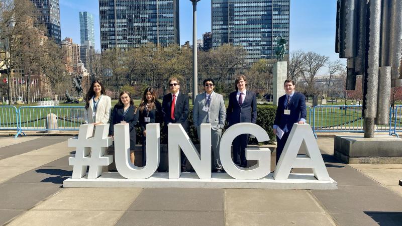 Students standing in front of a sign that reads #UNGA.