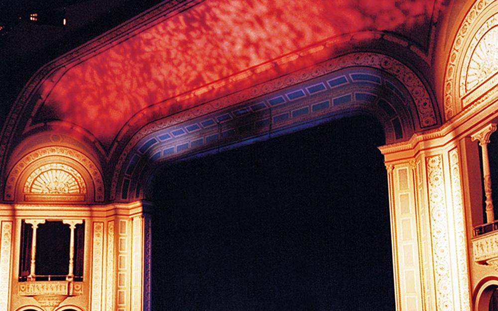 Bardavon 1869 Opera House showing the stage with red lighting on top and white lighting on the sides with 1 balcony high up on each side