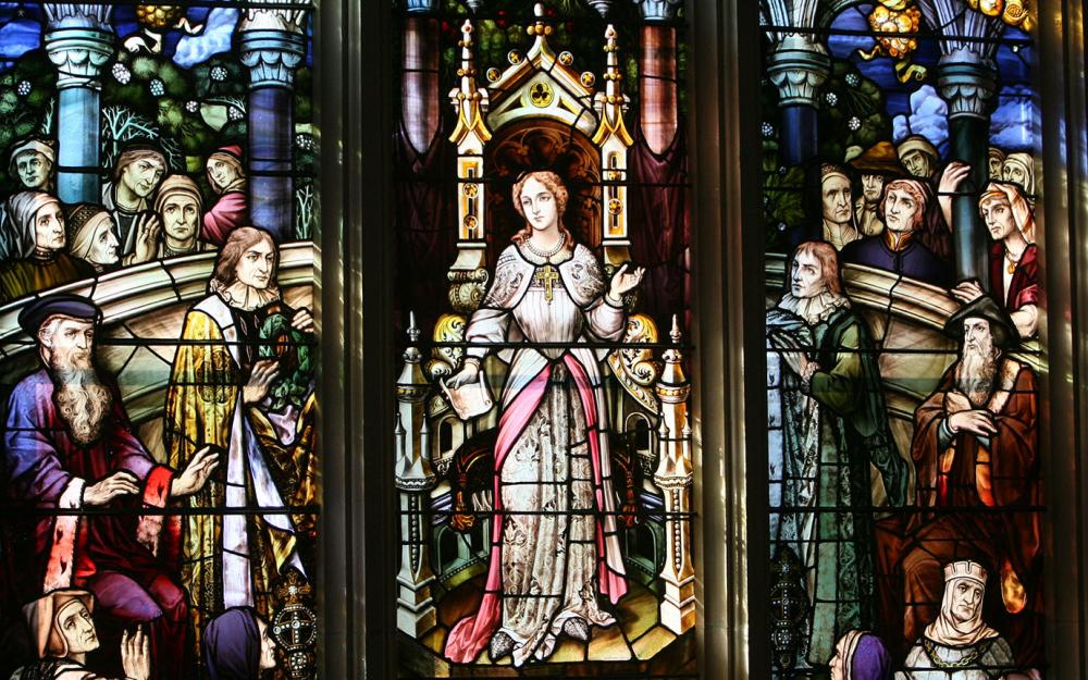 Cornaro stained glass window in the Thompson Library. In panes of painted and stained glass, the window depicts Elena Lucrezia Cornaro Piscopia (1646-84), the first woman to receive a doctorate, defending her thesis in the Cathedral of Padua in 1678.