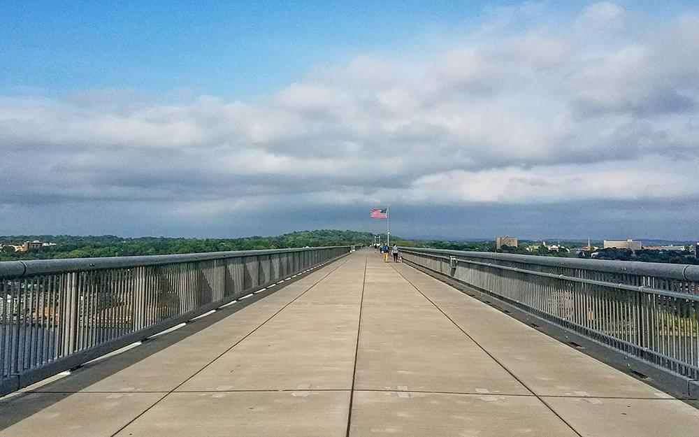 View on Walkway Over the Hudson bridge with some people and the halfway point flag