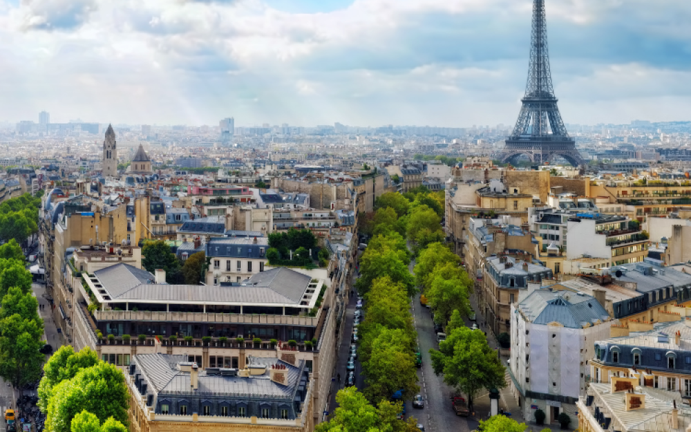 Paris view from above looking over neighborhoods with the Eiffel Tower in the distance.