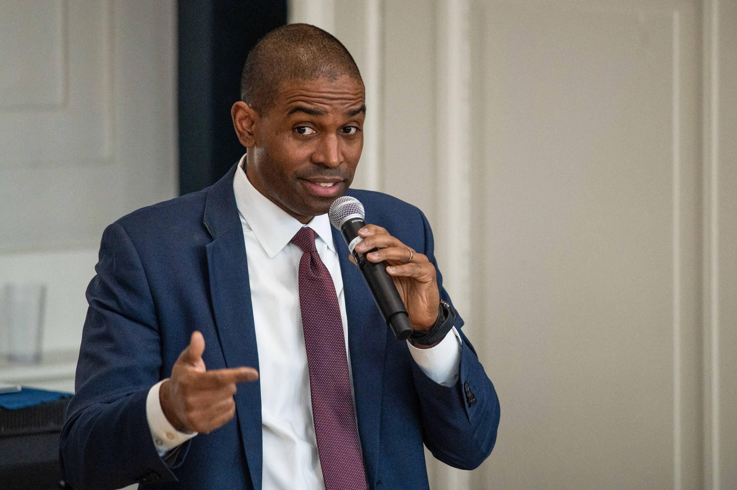 Person holding a microphone and speaking.