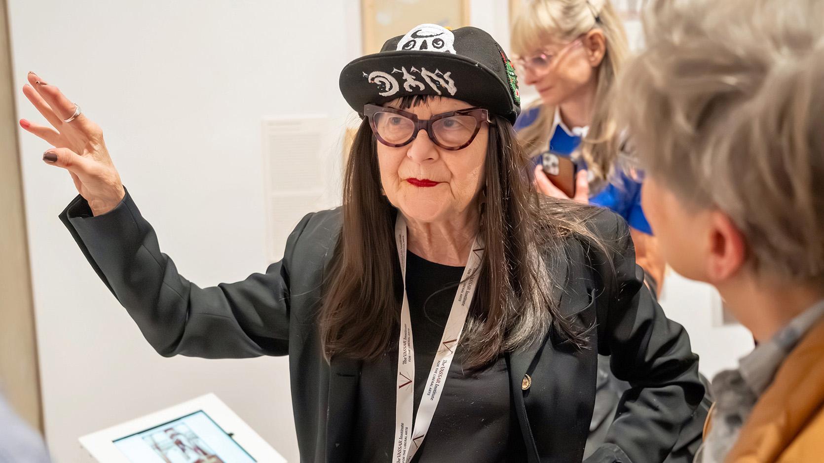 A speaker gestures while addressing visitors during the opening of an exhibition at the Frances Lehman Loeb Art Center, Vassar College.