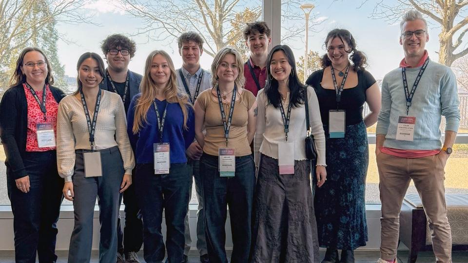 Group of people standing and smiling at a conference.