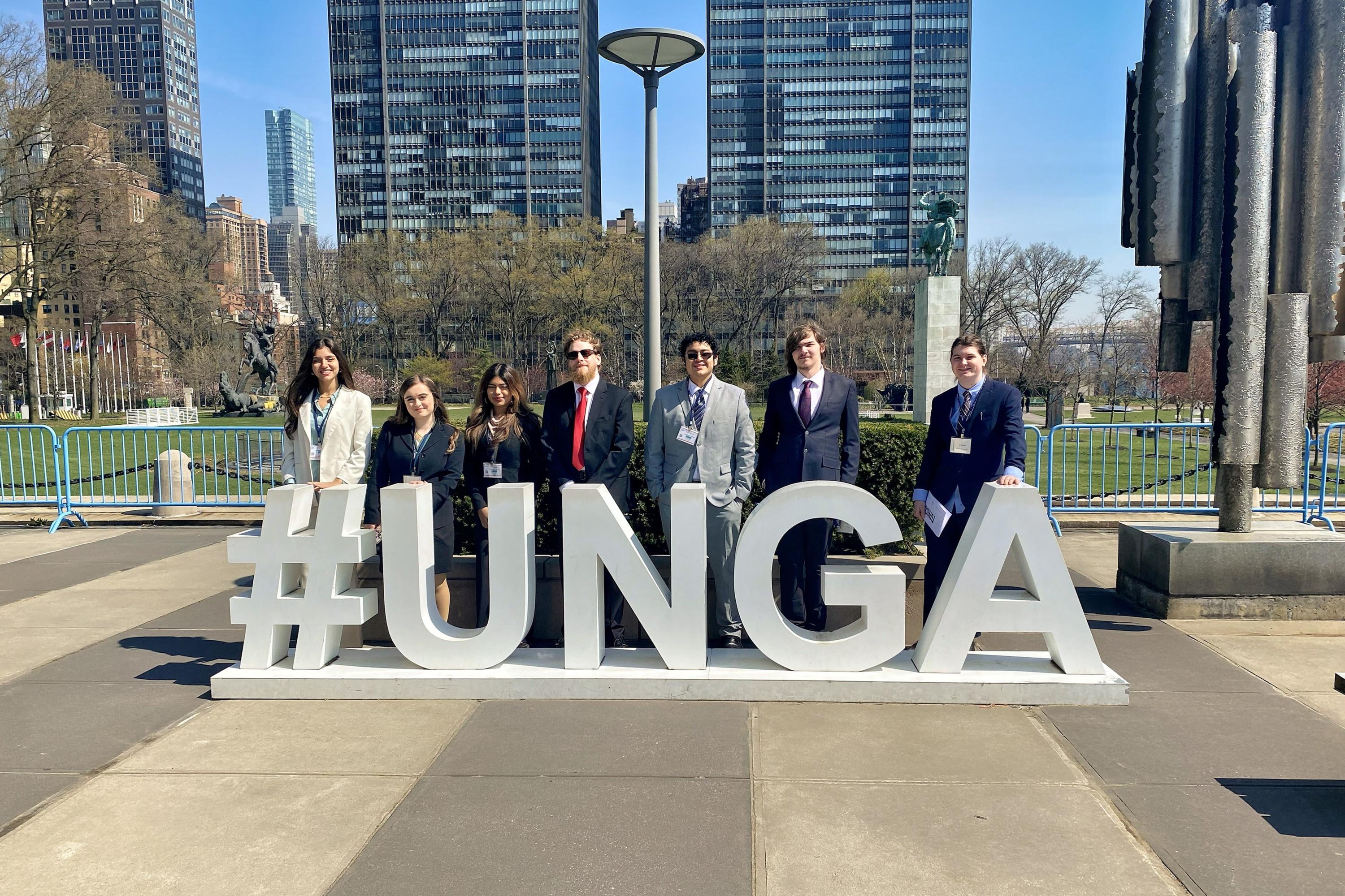 Students standing in front of a sign that reads #UNGA.