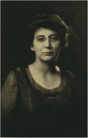 Old black and white photo of Professor Mary Evelyn Wells Ph.f8.96 wearing a dark shirt with a dark background.  