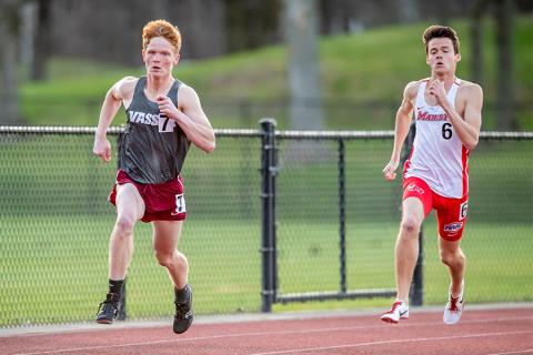 Tim Jacques races ahead of his opponent on an outdoor track.