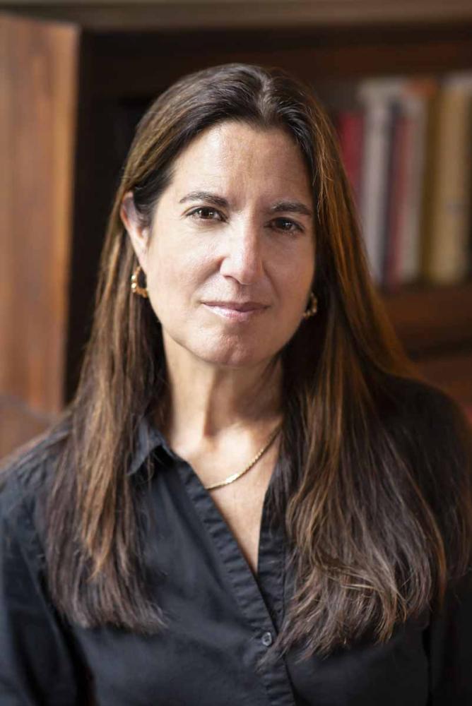 A headshot of Katherine Hite, a person with long brown hair and a black shirt.