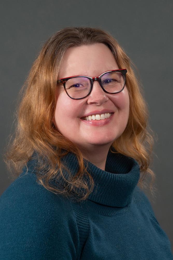 A studio portrait of a person on a dark background