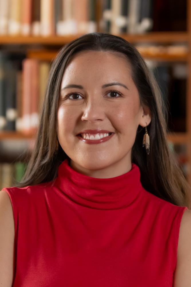 Portrait of a person with library shelves in the background.