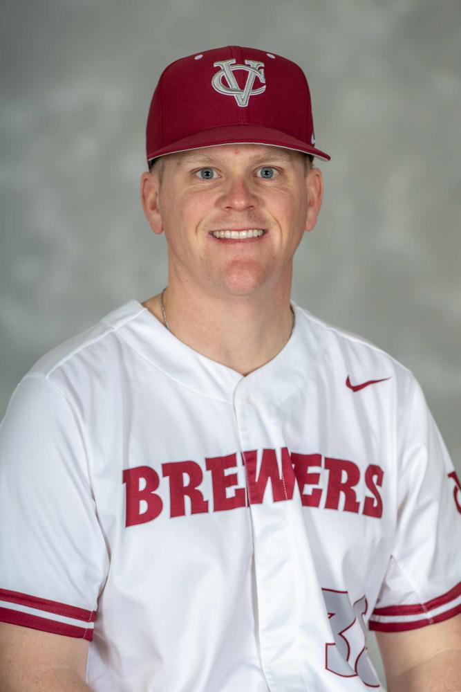 A portrait photo of Tad Skelly wearing a white and red Vassar Brewers shirt and baseball cap.