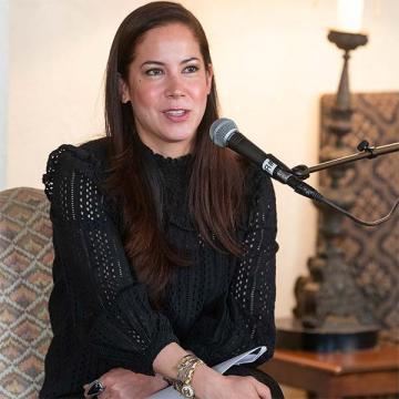 A young woman speaks in front of a microphone.