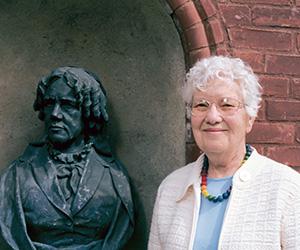 Vera Rubin standing outside Vassar's observatory next to the statue of Maria Mitchell.