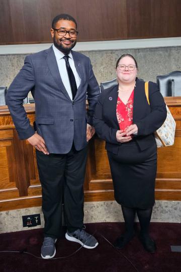 Two people standing side by side smiling for a photograph